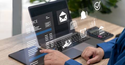 Zakenman achter laptop met icoontjes van budget en financiën